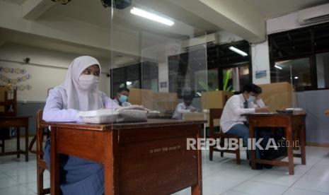 Sejumlah siswa dengan menjaga jarak dan menggunakan meja bersekat mengikuti persiapan Kompetisi Sains Nasional di SMAN 81 Jakarta, Senin (5/4). Pemerintah Provinsi (Pemprov) DKI akan melakukan uji coba pembelajaran tatap muka di 100 sekolah mulai 7 April hingga 29 April 2021 dengan menerapkan protokol kesehatan COVID-19. Skema yang diterapkan adalah para siswa belajar tatap muka secara bergantian. Prayogi/Republika