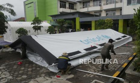 Petugas membangun tenda bagian dari rumah sakit darurat di halaman Rumah Sakit Umum Daerah (RSUD) Sumedang, di Kabupaten Sumedang, Jawa Barat, Rabu (3/1/2023). Pasca gempa Magnitudo 4.8 jelang Tahun Baru pekan lalu, gempa susulan masih mengguncang wilayah Kabupaten Sumedang. Terakhir, gempa berkekuatan lebih rendah Magnitudo 2,3 terjadi Rabu dini hari. Saat ini semua pihak dan unsur terkait tetap waspada dengan membangun sejumlah fasilitas darurat.