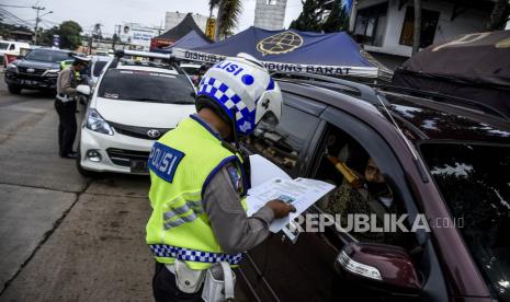 Petugas kepolisian memeriksa kelengkapan pengemudi yang hendak masuk tol melalui Pintu Gerbang Tol Padalarang, Kabupaten Bandung Barat, Kamis (28/5). Penyekatan tersebut dilakukan untuk menghalau pemudik dari kampung halaman untuk tidak kembali ke kota sebelumnya guna mengantisipasi lonjakan penyebaran kasus Covid-19