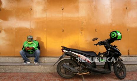 Pengemudi ojek daring menunggu pesanan di Makassar, Sulawesi Selatan, Sabtu (4/4/2020). ASN Makassar diwajibkan mendukung Ojol Day tiap Selasa mulai pekan ini. 