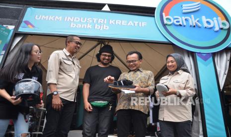 Direktur Komersial dan UMKM Bank BJB, Nancy Adistyasari (kanan), Pemimpin Divisi Kredit UMKM Bank BJB Denny Mulyadi dan Sekretaris Kemeterian Koordinator Bidang Perekonomian Susiwijono Moegiarso (kedua kanan) berbincang dengan pelaku usaha saat meninjau UMKM di acara KUR Festival bertajuk Expo Super Gen Creation di Gedung Sate, Kota Bandung, Jumat (17/3/2023). Kegiatan tahunan yang diselenggarakan oleh Kemenko Perekonomian bekerjasama dengan penyalur KUR (Kredit Usaha Rakyat) dan Penjamin KUR itu menghadirkan sejumlah booth industri kreatif UMKM karya anak muda. Acara berlangsung dari tanggal 17-18 Maret 2023.