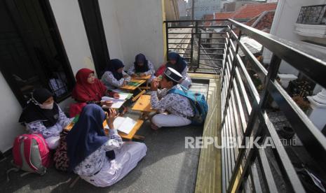 Siswa SD/MI Cokroaminoto mengikuti pelajaran di salah satu rumah warga di kawasan Nyamplungan, Surabaya, Jawa Timur, Kamis (19/1/2023). Pelajar SD/MI Cokroaminoto belajar di sejumlah rumah yang disediakan oleh pihak sekolah karena gedung sekolah YPI Cokroaminoto yang rencananya direnovasi terkendala tidak memiliki izin mendirikan bangunan (IMB) dan disegel Pemkot Surabaya. ANTARA FOTO/Didik Suhartono/nym.