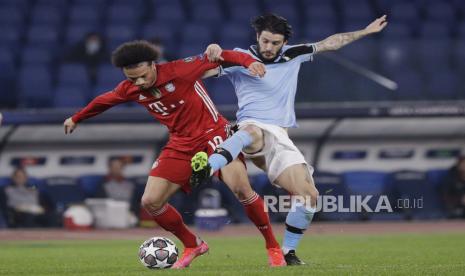 Luis Alberto dari Lazio, kanan, menantang bola dengan pemain Bayern Leroy Sane selama pertandingan leg pertama babak 16 besar Liga Champions antara Lazio dan Bayern Munich di Stadion Olimpiade di Roma, Selasa, 23 Februari 2021. 