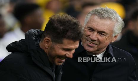 Pelatih kepala Real Madrid Carlo Ancelotti (kanan) tersenyum saat berbicara dengan pelatih kepala Atletico Madrid Diego Simeone menjelang pertandingan sepak bola La Liga Spanyol antara Real Madrid dan Atletico Madrid di stadion Santiago Bernabeu di Madrid, Spanyol, Ahad (26/2/2023) dini hari WIB. Ancelotti menduduki posisi kesembilan pelatih dengan trofi terbanyak. 