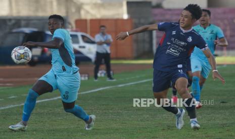 Pesepak bola Madura United Hugo Gomes (kiri) berebut bola dengan pesepak bola Arema FC Renshi (kanan) saat laga BRI Liga 1 di Stadion Sultan Agung, Bantul, D.I Yogyakarta, Selasa (20/12/2022). Madura United berhasil mengalahkan Arema FC dengan skor 2-0. 