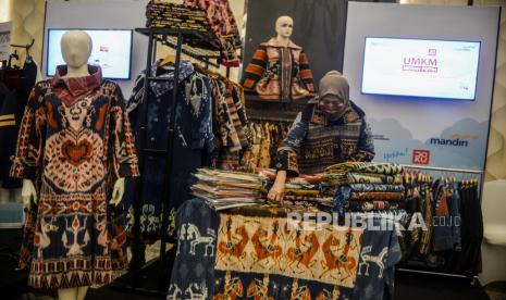 Peserta pameran merapikan produk yang dipamerkan pada acara UMKM Merah Putih 2022 di Jakarta, Selasa (29/11/2022). Bazar yang diikuti oleh ribuan UMKM yang sebagaian besar binaan dari Rumah BUMN tersebut berlangsung secara hybrid.