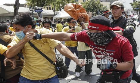  Seorang pengunjuk rasa pro-demokrasi bentrok dengan pengunjuk rasa pro-monarki selama protes anti-pemerintah di monumen demokrasi di Bangkok, Thailand, 14 Oktober 2020. Pengunjuk rasa pro-demokrasi mengambil bagian dalam unjuk rasa melawan elit royalis dan pemerintah yang didukung militer menyerukan pengunduran diri Perdana Menteri Thailand Prayut Chan-o-cha, penulisan ulang piagam baru monarki yang direformasi di bawah konstitusi.