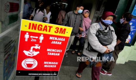 Papan protokol kesehatan Covid-19 dipajang di pintu masuk Pasar Beringharjo, Yogyakarta, Jumat (1/1). Libur Tahun Baru 2021 wisatawan memadati kawasan Pasar Beringharjo. Di sini wisatawan membeli batik atau baju untuk oleh-oleh dengan harga murah.