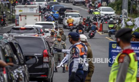 Sejumlah petugas gabungan melakukan pembatasan kendaraan di Jalan Raya Puncak, Gadog, Kabupaten Bogor, Jawa Barat, Sabtu (3/10/2020). Pemerintah Kabupaten Bogor bersama unsur TNI-Polri melakukan pembatasan pengunjung sebesar 50 persen di kawasan wisata Puncak Kabupaten Bogor, hal tersebut sebagai upaya mencegah membludaknya pengunjung serta dalam mengantisipasi penyebaran COVID-19. 