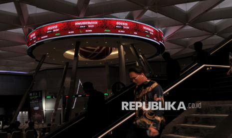 Pekerja berjalan disamping refleksi layar yang menampilkan data pergerakan perdagangan saham saat pembukaan perdagangan saham tahun 2025 di Gedung Bursa Efek Indonesia, Jakarta, (ilustrasi)