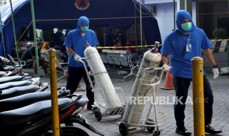 Tenaga kesehatan membawa tabung oksigen untuk pasien Covid-19 di tenda darurat khusus Covid-19 Rumah Sakit Umum Pusat (RSUP) Dr Sardjito, Yogyakarta, Ahad (4/7). Posko Dukungan Operasi Satgas COVID-19 BPBD DIY mengonfirmasi sebanyak 63 pasien di RSUP Dr Sardjito Yogyakarta meninggal dunia dalam sehari semalam pada Sabtu (3/7) hingga Ahad (4/7) pagi akibat menipisnya stok oksigen.