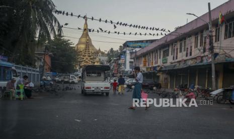  Penjual jalanan membaca koran di jalan menuju kuil Buddha Shwedagon di Yangon, Myanmar, Selasa, 2 Februari 2021. Ratusan anggota Parlemen Myanmar tetap terkurung di dalam perumahan pemerintah mereka di ibu kota negara itu pada Selasa, sehari setelah militer melancarkan kudeta dan menahan politisi senior termasuk pemenang Nobel dan pemimpin de facto Aung San Suu Kyi.