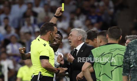 Wasit Artur Dias (kiri) memberikan kartu kuning kepada pelatih kepala Real Madrid Carlos Ancelotti (kanan) saat pertandingan sepak bola leg pertama semifinal Liga Champions UEFA antara Real Madrid dan Manchester City, di Madrid, Spanyol,  Rabu (10/5/2023) dini hari WIB. 