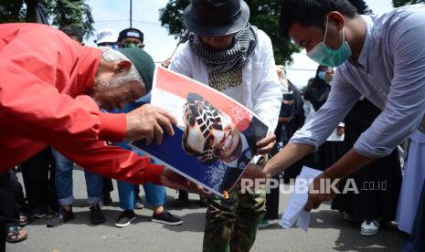 Massa membakar foto Presiden Prancis Emmanuel Macron saat unjuk rasa mengutuk pernyataan Emmanuel Macron yang dinilai menghina umat Islam karena membiarkan publikasi karikatur yang melecehkan Nabi Muhammad SAW, di depan Gedung Sate, Jalan Diponegoro, Kota Bandung, Senin (2/11). Aksi tersebut di antaranya menyerukan kepada umat agar memboikot produk-produk Prancis dan meminta agar Emmanuel Macron meminta maaf kepada umat Islam.