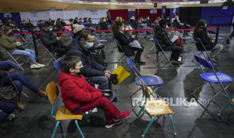  Dimitri Marck, 8, tengah, menunggu bersama ayahnya Matthieu Marck di National Velodrome di Saint-Quentin-en-Yvelines, barat Paris, Prancis, Rabu, 22 Desember 2021. Angka kasus infeksi harian virus corona Prancis kembali tembus rekor hingga mendekati 100 ribu kasus. 