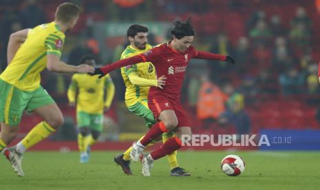 Pemain Liverpool Takumi Minamino, kanan, berebut bola dengan pemain Norwich City Pierre Lees-Melou, tengah, selama pertandingan sepak bola Piala FA Inggris antara Liverpool dan Norwich City di stadion Anfield di Liverpool, Inggris, Kamis (3/3/2022).