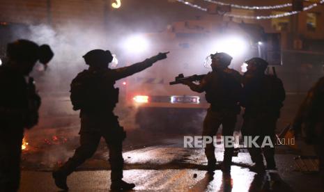  Petugas polisi Israel menembakkan granat kejut ke arah demonstran Palestina selama bentrokan di Gerbang Damaskus di luar Kota Tua Yerusalem, Sabtu, 8 Mei 2021.