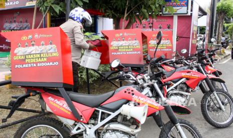 Petugas menyiapkan peralatan vaksinasi di motor roda dua keliling di Posko Siaga Vaksin 24 Jam, kawasan Pos Polisi Bundaran Taman Pinang Indah, Sidoarjo, Jawa Timur, Rabu (27/10/2021). Polresta Sidoarjo membuka Posko Siaga Vaksin 24 Jam dengan menyiagakan enam gerai mobil dan motor roda dua vaksinasi keliling pedesaan untuk melayani vaksinasi COVID-19. 