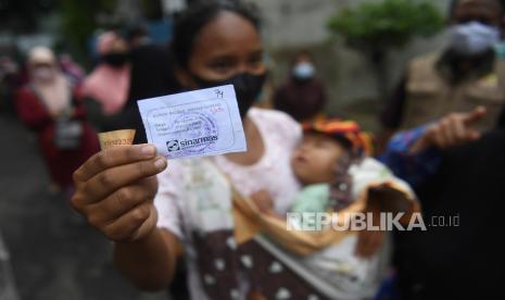 Warga menunjukkan kupon saat mengantre untuk membeli minyak goreng dengan harga murah saat operasi pasar di Johar Baru, Jakarta, Senin (17/1/2022). Operasi pasar tersebut dilakukan untuk mengatasi kelangkaan minyak dan menstabilkan harga minyak goreng di pasaran. (ilustrasi)