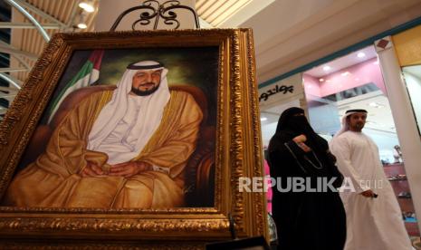  (FILE) - Seorang pria UEA bersama istrinya berjalan melewati potret Presiden UEA dan Penguasa Abu Dhabi Sheikh Khalifa bin Zayed al-Nahyan di Dubai, Uni Emirat Arab, 02 Desember 2008 (Diterbitkan kembali 13 Mei 2022). Menurut kantor berita negara Emirates WAM pada 13 Mei 2022 Presiden Uni Emirat Arab Sheikh Khalifa Bin Zayed Al Nahyan telah meninggal pada usia 73 tahun.