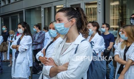 Penghuni khusus medis lulusan ARS-CoPost mengenakan masker saat mereka mengambil bagian dalam protes di depan kursi pemerintah daerah Lombardy untuk menuntut perbaikan kondisi dan perlindungan di tempat kerja, serta pengakuan pemerintah atas pekerjaan mereka selama pandemi yang sedang berlangsung dari penyakit COVID-19 yang disebabkan oleh coronavirus SV-2 di Milan, Italia utara, 22 Juni 2020.