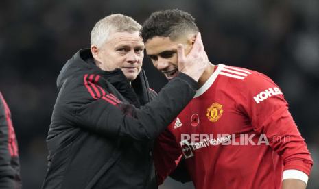  Manajer Manchester United Ole Gunnar Solskjaer, kiri, menyapa pemain Manchester United Raphael Varane setelah pertandingan sepak bola Liga Inggris antara Tottenham Hotspur dan Manchester United di Stadion Tottenham Hotspur di London, Ahad (31/10). 