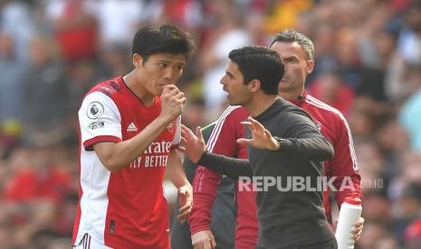 Manajer Arsenal Mikel Arteta (kanan) berbicara dengan Takehiro Tomiyasu (kiri) selama pertandingan sepak bola Liga Premier Inggris antara Arsenal FC dan Leeds United di London, Inggris, 08 Mei 2022.