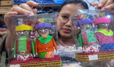 Pekerja menunjukkan miniatur ondel-ondel yang telah selesai dibuat di Betawi Online Galeri, Setu Babakan, Jakarta Selatan, Selasa (2/2/2021). Kementerian Koperasi (Kemenkop) dan UKM menetapkan enam strategi yang akan diterapkan tahun ini untuk membangkitkan sektor koperasi dan UMKM meliputi bidang perkoperasian, usaha mikro, UKM, kewirausahaan, penyaluran dana bergulir, dan penguatan pemasaran produk. 