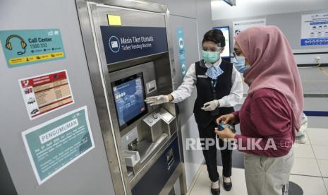 Petugas mengarahkan calon penumpang menggunakan mesin tiket otomatis di Stasiun MRT Bundaran Hotel Indonesia, Jakarta, Rabu (6/1/2021). Direktur Utama PT MRT Jakarta (Perseroda) William Syahbandar berharap sistem integrasi tiket dan pembayaran angkutan massal di wilayah Jabodetabek dapat terwujud pada 2022 melalui suatu subholding perusahaan yang mengelola tiket bagi MRT, LRT, KRL dan Transjakarta. 