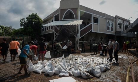 Personel gabungan dari TNI, Polri, petugas Pemadam Kebakaran, PPSU, dan warga sekitar membersihkan endapan lumpur sisa banjir di area Masjid Al-Hidayah, Cipinang Melayu. Jakarta Timur, Senin (22/2). Kegiatan kerja bakti tersebut dilakukan diarea tempat ibadah agar dapat digunakan kembali untuk beribadah. Republika/Thoudy Badai