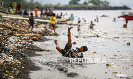  Anak-anak bermain di pantai sambil berenang antara sampah yang mengapung di laut di Pantai Kalumata Ternate, Maluku Utara, Jumat (15/11/2024). 