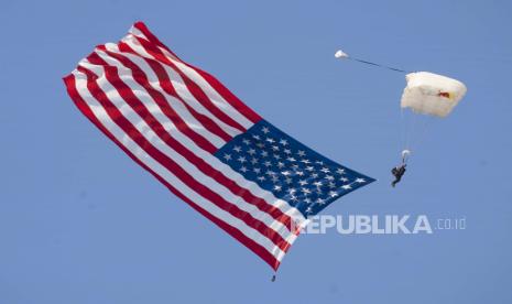  11 Mahasiswa Asal Padang Panjang Diberangkatkan ke Amerika. FOto: Seorang penerjun payung mengibarkan bendera Amerika saat Star Spangled Banner dimainkan untuk membuka The Great State of Maine Air Show di Brunswick Executive Airport di Brunswick, Maine, Sabtu, 4 September 2021. Seorang Marinir yang meninggal empat tahun lalu sedang dikenang akhir pekan ini di Great State of Maine Air Show, yang diadakan 10 tahun setelah penutupan Brunswick Naval Air Station.