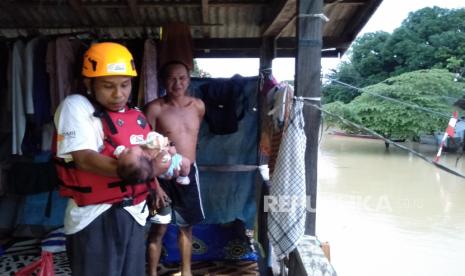 Relawan mengevakuasi seorang balita saat banjir di Desa Sinar Bulan, Kabupaten Tanah Bumbu, Kalimantan Selatan. Berdasarkan data Badan Nasional Penanggulangan Bencana (BNPB) sebanyak 14.891 jiwa terdampak banjir yang terjadi di dua lokasi Kabupaten Tanah Bumbu dan Kabupaten Tanah Laut akibat tingginya intensitas hujan di Kalimantan Selatan. 