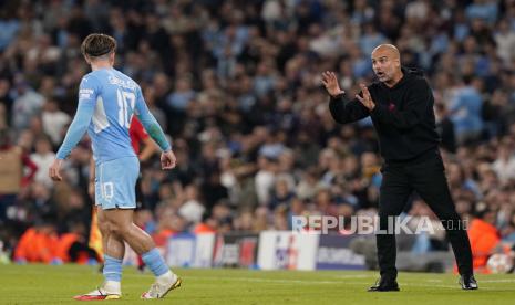 Pelatih Manchester City Pep Guardiola (kanan) memberikan instruksi kepada Jack Grealish (kiri) pada pertandingan sepak bola grup A Liga Champions UEFA antara Manchester City dan RB Leipzig di Manchester, Inggris, Kamis (16/9) dini hari WIB. 