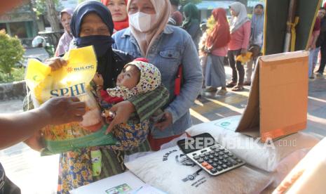 Warga antre untuk membeli beras dalam pasar murah di depan kantor Dinas Ketahanan Pangan dan Pertanian, Ngawi, Jawa Timur, Jumat (26/1/2024). Pasar murah  tersebut diadakan setiap hari Jumat dan sudah berlangsung selama 3 bulan terakhir untuk menekan inflasi terutama harga beras yang hingga kini tak kunjung turun dan berada di kisaran Rp13.000 per kilogram meski di kawasan tersebut mengalami surplus beras