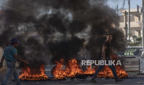 Warga Palestina membakar ban dan bentrok dengan tentara Israel mengamankan parameter rumah Palestina Amerika Muntasser Shalaby yang dihancurkan dengan ledakan terkendali di desa Turmus Ayya Tepi Barat, utara Ramallah, Kamis, 8 Juli 2021. Pasukan Israel pada Kamis menghancurkan Rumah keluarga Shalaby setelah dituduh terlibat dalam serangan mematikan terhadap warga Israel di Tepi Barat pada Mei.