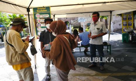 Pemandu wisata memeriksa identitas bukti vaksin Covid-19 pengunjung di Objek Wisata Tamansari, Yogyakarta, Selasa (29/10). Pembukaan objek wisata Tamansari ini masih dalam tahap uji coba. Ada tiga spot yang baru dibuka yakni Gedong Sekawan, Kolam, dan Lopak-lopak. Wajib vaksin Covid-19 menajdinsalah satu syarat untuk bisa masuk ke Tamansari.