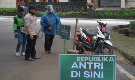 Petugas menyemprotkan desinfektan kepada setiap ojek online atau ojol yang datang, di Jalan Hegarmanah, Kota Bandung, Jawa Barat, beberapa waktu lalu. Ojol di Kota Bandung sudah boleh mengakut penumpang, tapi fitur pemesanan ojol di aplikasi belum aktif.