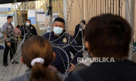  Seorang pejabat bea cukai Amerika Serikat berbicara dengan orang-orang yang menunggu untuk menyeberang di Pelabuhan Masuk San Ysidro, Senin, 8 November 2021, di Tijuana, Meksiko. Meksiko-AS tingkatkan modernisasi infrastruktur dan proses penyeberangan perbatasan. 