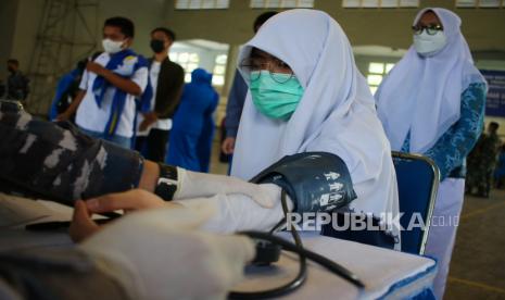 Petugas kesehatan memeriksa tekanan darah anak sebelum divaksin COVID-19 di GOR Basket Bumimoro, Surabaya, Jawa Timur, Selasa (24/8). Kepala Bagian Humas Pemkot Surabaya, Febriadhitya Prajatara mengatakan, capaian vaksinasi dosis pertama di Surabaya saat ini mencapai 77 persen.