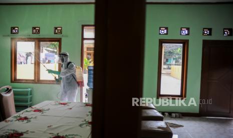 Seorang pengurus RW menyemprotkan cairan disinfektan di sebuah ruangan isolasi mandiri 