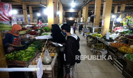 Pedagang bertransaksi dengan jarak aman yang dipasang oleh pengelola Pasar Beringharjo di los sayuran saat pandemi virus corona, Yogyakarta, Selasa (21/4). Pemasangam jarak 50 centimeter ini untuk menjaga jarak aman dari penularan virus corona