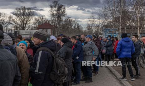 Penduduk setempat menunggu dalam antrian untuk menerima bantuan kemanusiaan, direbut kembali oleh tentara Ukraina kota Trostyanets, di wilayah Sumy, Ukraina, 29 Maret 2022 (dikeluarkan 30 Maret 2022). Trostyanets direbut kembali oleh tentara Ukraina setelah kota itu berada di bawah pasukan Rusia sejak hari-hari pertama perang selama lebih dari sebulan. 