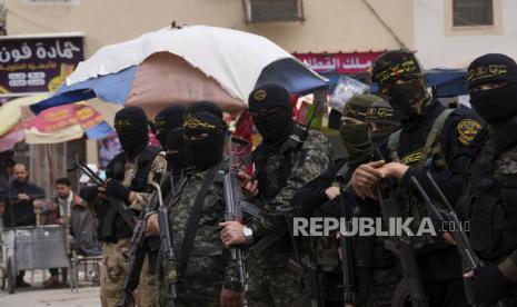 Anggota Brigade Al-Quds bertopeng, sayap militer kelompok Jihad Islam, memegang senjata mereka selama rapat umum merayakan penembakan malam terakhir di Israel di mana seorang penyerang Palestina membunuh dua orang Israel setelah shalat Jumat di luar masjid utama di Khan Younis Kota, Jalur Gaza selatan, Jumat, 8 April 2022.