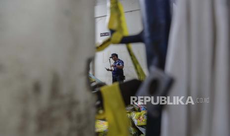 petugas polisi forensik menyelidiki di dekat pintu masuk tribun gerbang 13, lokasi utama penyerbuan, di Stadion Kanjuruhan di Malang, Jawa Timur, Indonesia, 06 Oktober 2022. Presiden Indonesia telah memerintahkan penyelidikan dan audit ke semua stadion sepak bola di negara ini, untuk memastikan keselamatan bagi para penggemar setelah setidaknya 131 orang tewas dalam kerusuhan dan penyerbuan menyusul pertandingan sepak bola antara Arema FC dan Persebaya Surabaya di Jawa Timur pada 01 Oktober 2022.