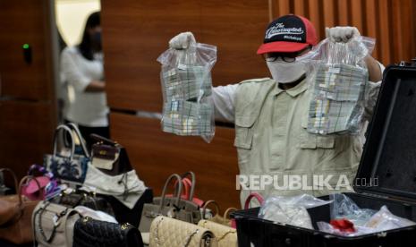 Petugas menunjukan uang sitaan saat konferensi pers pengumuman penahanan tersangka di Gedung Merah Putih KPK, Jakarta, Senin (3/4/2023). KPK resmi melakukan penahanan terhadap tersangka Rafael Alun Trisambodo (RAT) dalam kasus dugaan tindak pidana korupsi dengan menggunakan jabatannya atas penerimaan gratifikasi dari beberapa wajib pajak terkait pengkondisian berbagai temuan pemeriksaan perpajakan di Ditjen Pajak Kemenkeu tahun 2011 hingga 2023. Dalam konferensi pers tersebut, KPK juga berhasil menyita sejumlah tas mewah, perhiasan dan sejumlah mata uang dollar Amerika, dollar Singapura dan mata uang euro senilai Rp32,2 miliar saat melakukan penggeledahan di kediaman RAT. Oleh karena itu, untuk kepentingan penyidikan, KPK melakukan penahanan terhadap RAT selama 20 hari pertama dari tanggal 3-22 April 2023 mendatang di Rutan KPK Gedung Merah Putih.