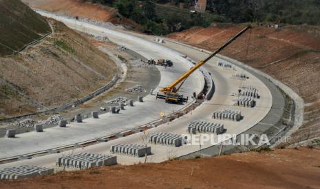 Pekerja mengoperasikan alat berat untuk memasang pembatas jalan pada proyek jalan tol (ilustrasi). Kementerian Pekerjaan Umum Perumahan Rakyat (PUPR) memastikan saat ini tengah melakukan proses penyederhanaan prosedur proyek kerja sama pemerintah dengan badan usaha (KPBU).