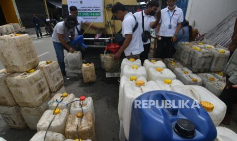 Petugas PT Perusahaan Perdagangan Indonesia (Persero) mengisi minyak goreng curah ke dalam jeriken pedagang pengecer di Pasar Masomba di Palu, Sulawesi Tengah, Jumat (18/3/2022). Kemendag melarang industri menengahbdan besar menggunakan minyak goreng curah.