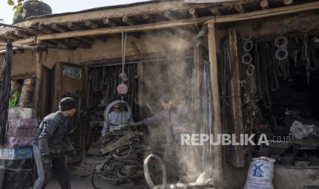 Seorang pemilik toko menimbang potongan karet untuk dijual, di Kabul, Afghanistan, Ahad, 14 November 2021.