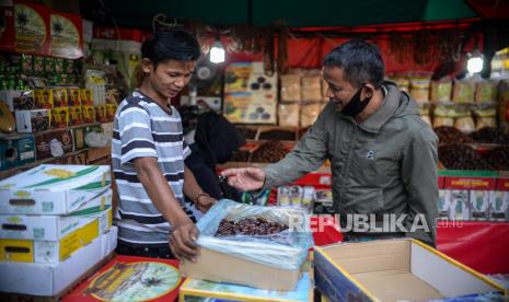 Pembeli memilah makanan kurma di gerai oleh-oleh haji umroh di kawasan Pasar Tanah Abang, Jakarta, Jumat (11/6). Pada musim haji sejumlah pedagang mengaku mengalami penurunan omset mencapai 80 persen seiring dengan kebijakan pemerintah terkait pembatalan ibadah Haji tahun 2021 akibat pandemi Covid-19. Sebelum pandemi covid-19 menyebar di Indonesia, pada saat musim haji, pedagang mampu menjualn sebanyak 500 paket oleh-oleh haji namun kini hanya menjual untuk makanan sehari-hari. Republika/Thoudy Badai